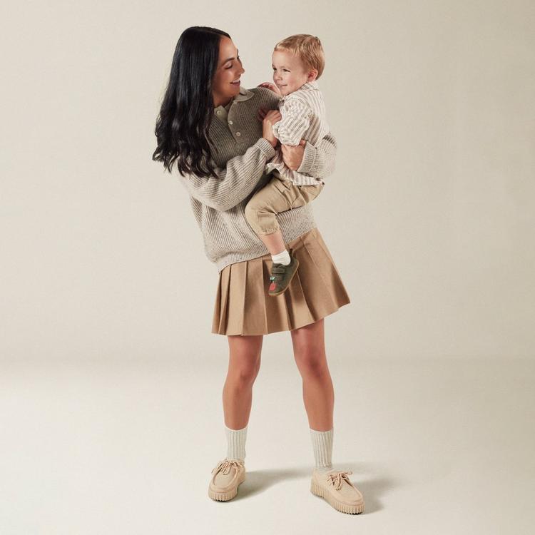 Woman holding baby wearing Clarks Roamer Garden dark olive toddler pre-walking shoes.